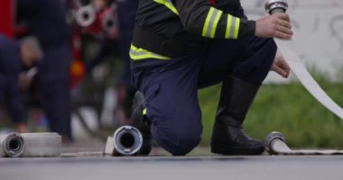 İtfaiyecilerden oluşan özel bir ekip bir itfaiye aracından hortumları alıyor ve tehlikeli bir tehlikeyle mücadele etmedeki cesaret ve profesyonel uzmanlıklarını sergileyerek, yanan bir yangını söndürmek için tehlikeli bir göreve çıkıyorlar.