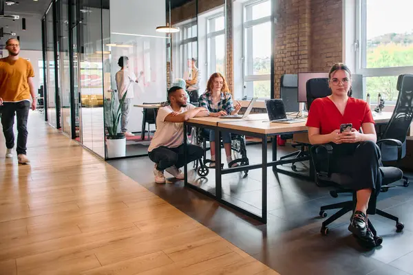 stock image A diverse group of business professionals collaborates in a modern startup coworking center, utilizing a mix of paper-based and technological tools such as mobile phones and computers .