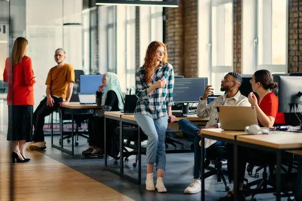 stock image A diverse group of young business individuals congregates in a modern startup coworking center, embodying collaborative innovation and a dynamic atmosphere.