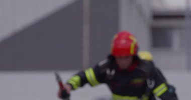 İtfaiyecilerden oluşan özel bir ekip bir itfaiye aracından hortumları alıyor ve tehlikeli bir tehlikeyle mücadele etmedeki cesaret ve profesyonel uzmanlıklarını sergileyerek, yanan bir yangını söndürmek için tehlikeli bir göreve çıkıyorlar.