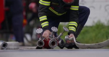 İtfaiyecilerden oluşan özel bir ekip bir itfaiye aracından hortumları alıyor ve tehlikeli bir tehlikeyle mücadele etmedeki cesaret ve profesyonel uzmanlıklarını sergileyerek, yanan bir yangını söndürmek için tehlikeli bir göreve çıkıyorlar.