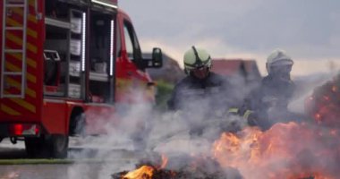 İtfaiyeciler yangını kontrol etmek için alevlerle savaşır, yayılmak için değil. İtfaiyeci endüstriyel ve kamu güvenliği kavramı. Trafik ya da araba kazası kurtarma ve eyleme yardım. Yüksek kalite fotoğraf