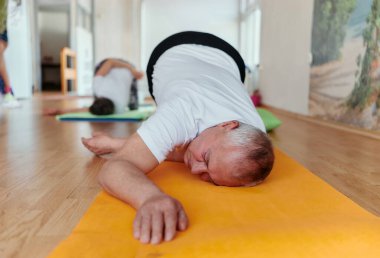 Üst düzey bir adam sağlığını korumak ve canlı ve aktif bir yaşam tarzı sürdürmek için boyun ve sırt egzersizleri yapar..