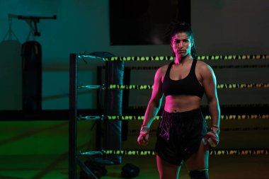 Siyah arka planda spor bandajlı genç seksi Latin boksör kadın güçlü ve kendine güvenen boksör kızla dövüşmeye hazırlanıyor.