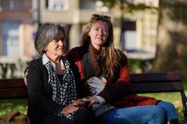 Güzel bir günde, sakin bir parkta, bir kız büyük annesini sevgiyle kucaklıyor, birlikte geçirdikleri güzel bir anı paylaşırken ona destek ve neşe sunuyor..