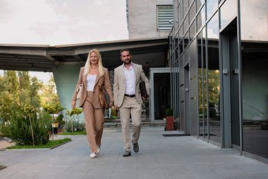 Uzun bir çalışmadan sonra modern iş çifti, evlerinin rahatlığı için birlikte yürüyorlar, profesyonel başarı ve kişisel memnuniyetin mükemmel bir karışımını oluşturuyorlar..