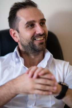 Ofiste otururken akıllı telefonuyla konuşan bir işadamı profesyonel tavrını ve aktif iletişimini gösteriyor.