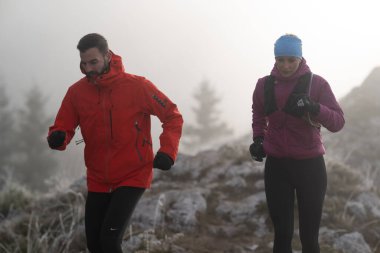 Dağ yolunda koşan bir çiftin izini sürüyorum. Bir çift sabahın erken saatlerinde kros koşusu yapıyor..
