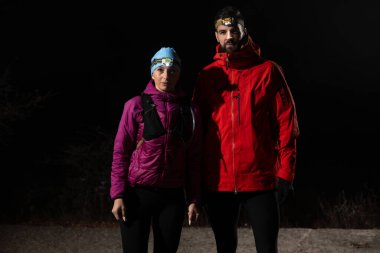 Patika koşucuları, sabahın erken saatlerinde bir far ile koşuya hazırlanırken portre çizerler..