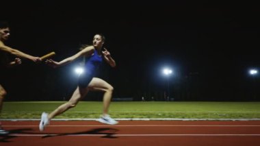 Atletizm çifti, bayrak yarışı koşan erkek ve kadın atletizm yarış pisti konseptini devrediyorlar. Yüksek kalite ağır çekim 4k görüntü
