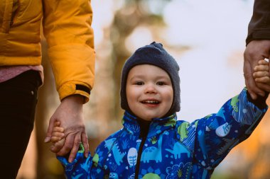 Aileler oğluyla birlikte büyüleyici şehir sokaklarında el ele yürüyorlar mevsimin sıcaklığının tadını çıkarıyorlar ve birlikte neşeli anılar yaratıyorlar.