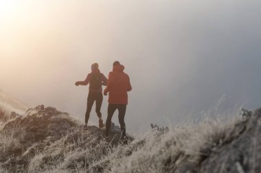 Dağ yolunda koşan bir çiftin izini sürüyorum. Bir çift sabahın erken saatlerinde kros koşusu yapıyor..