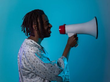 African American man dons traditional attire, passionately utilizing a megaphone against a striking blue background, symbolizing his vocal and cultural empowerment in the pursuit of social justice and clipart