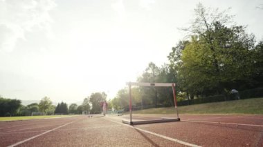 İş adamı atletizm pistinde koşarken engelden atlıyor. Yüksek kalite 4 bin yavaş çekim görüntüsü