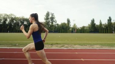 Büyük bir stadyum atletizm pistinde antrenman yapan profesyonel bayan sporcu. Yüksek kalite 4 bin yavaş çekim.