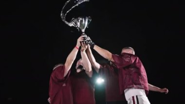 Amerikan Futbol Takımı, sahanın ortasında Beyaz Üniformalı, Zafer Kazanan Zafer Oyununu kutluyor. Yüksek kaliteli ağır çekim sinematik 4k görüntü