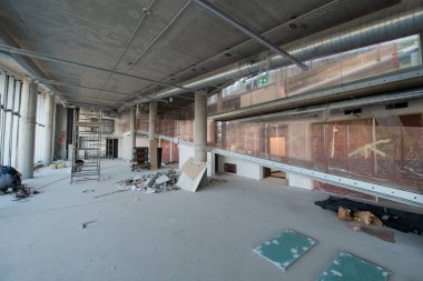 Yapım aşamasındaki modern bir iş binasının büyüleyici bir görüntüsü, çiğ endüstriyel iç mekânını, gün batımının sıcak, altın sarısı renkleri ile yıkanmış çelik kirişleri ve beton duvarlarıyla sergiliyor.. 