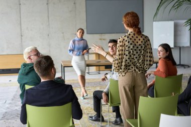 A diverse group of business professionals sits attentively in a modern office, actively participating in a training session led by an instructor, focusing on the latest technological advancements in clipart