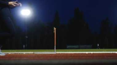 Dişi sporcu bir engele doğru koşuyor, engelli koşuyor, yüksek hızda bariyerin üzerinden atlıyor bir yarışta koşarken. Hız Rampası Efektli Süper Yavaş Sinema Görüntüsü.