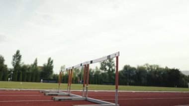 Stadyuma atletik zinde bir çift erkek ve kadın fırlatılıyor. Sıcak bir yaz öğleden sonrasında engellerin üzerinden atlamak. Yavaş Hareket İzleme Görüntüsü. 