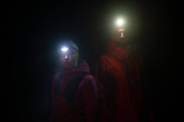 Patika koşucuları, sabahın erken saatlerinde bir far ile koşuya hazırlanırken portre çizerler..