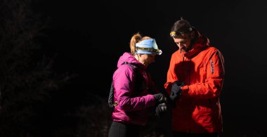 Eğitimden sonra nefes almaktan sıkılan koşucular, teknoloji sporu saatlerine bakmaktan, kalp atış hızı verilerini ve navigasyonlarını kontrol etmekten bıktılar. İki sporcu bir dağda birlikte koşuyor..