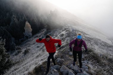 Dağ yolunda koşan bir çiftin izini sürüyorum. Bir çift sabahın erken saatlerinde kros koşusu yapıyor..