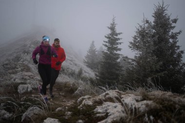 Dağ yolunda koşan bir çiftin izini sürüyorum. Bir çift sabahın erken saatlerinde kros koşusu yapıyor..
