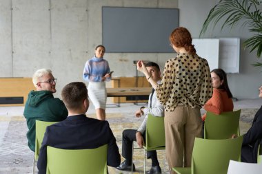 A diverse group of business professionals sits attentively in a modern office, actively participating in a training session led by an instructor, focusing on the latest technological advancements in clipart