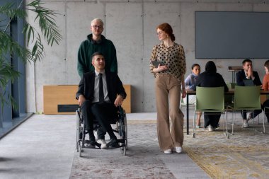 A diverse team of business colleagues, including a director in a wheelchair, engages in a collaborative discussion as they move together through a modern office space.  clipart