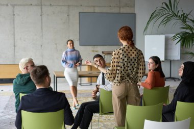 A diverse group of business professionals sits attentively in a modern office, actively participating in a training session led by an instructor, focusing on the latest technological advancements in clipart