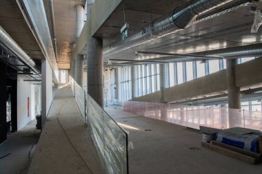 Yapım aşamasındaki modern bir iş binasının büyüleyici bir görüntüsü, çiğ endüstriyel iç mekânını, gün batımının sıcak, altın sarısı renkleri ile yıkanmış çelik kirişleri ve beton duvarlarıyla sergiliyor.. 