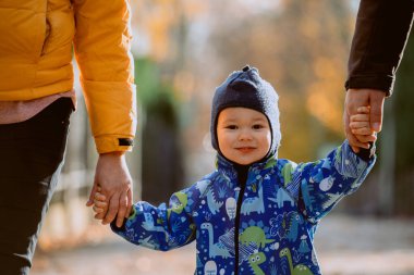 Aileler oğluyla birlikte büyüleyici şehir sokaklarında el ele yürüyorlar mevsimin sıcaklığının tadını çıkarıyorlar ve birlikte neşeli anılar yaratıyorlar.