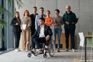 Multiethnic Business Team Collaborating in a Modern Office with Director in a Wheelchair. clipart