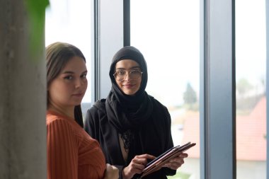 İki meslektaş bir tablete bakarken verimli bir konuşma yapıyorlar. 