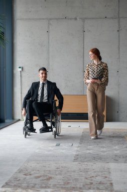 Director in a Wheelchair Navigating the Office While Discussing Business Challenges with a Colleague. clipart