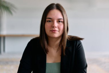 Meslektaşlarıyla fikir ve stratejileri tartışan profesyonel bir toplantıya katılan genç bir iş kadınının yakın plan portresi.. 