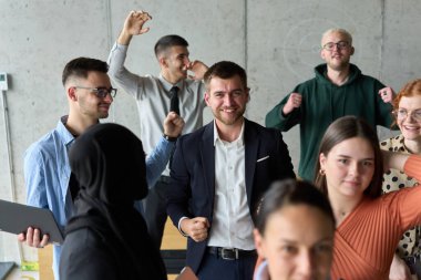 Çeşitli iş adamlarından oluşan bir ekip modern bir ofiste başarılarını coşkuyla kutluyor, amaçlarına ulaştıktan sonra zafer ve birlik içinde olduklarını ifade ediyorlar.. 