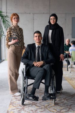 A diverse business team poses confidently, including a smiling director seated in a wheelchair, flanked by two professional female colleagues, one wearing a hijab and the other holding a tablet, in a clipart