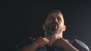 Bir Amerikan futbolcusunun yakın plan portresi yoğun bir antrenmandan sonra terliyor, atletizm ve kararlılık sergiliyor. Sporla ilgili içerik ve motivasyonel görseller için ideal