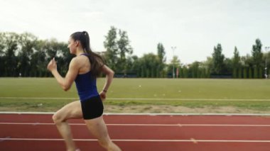 Büyük bir stadyum atletizm pistinde antrenman yapan profesyonel bayan sporcu. Yüksek kalite 4 bin yavaş çekim.