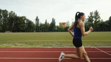 Büyük bir stadyum atletizm pistinde antrenman yapan profesyonel bayan sporcu. Yüksek kalite 4 bin yavaş çekim.