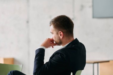 Karizmatik bir yönetmenin bir iş toplantısında otururken, üretken bir tartışmayla uğraşırken özgüven, odaklanma ve liderlik sergilediği yakın çekim.