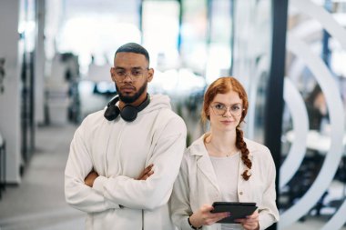 Modern bir ofiste, Afro-Amerikan iş adamı ve iş kadını meslektaşı, çarpıcı turuncu saçlarıyla, işbirlikçi problem çözme seanslarına katılırlar..