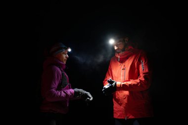 Eğitimden sonra nefes almaktan sıkılan koşucular, teknoloji sporu saatlerine bakmaktan, kalp atış hızı verilerini ve navigasyonlarını kontrol etmekten bıktılar. İki sporcu bir dağda birlikte koşuyor..