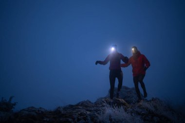 Gecenin karanlığında dağda koşan kadın ve erkek izci. Samanyolu 'nda. Yüksek kalite fotoğraf