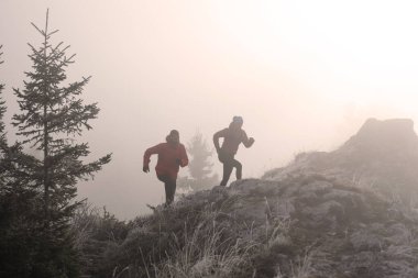 Dağ yolunda koşan bir çiftin izini sürüyorum. Bir çift sabahın erken saatlerinde kros koşusu yapıyor..