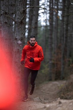 Patika koşucusu dağ ormanına doğru gidiyor. Sabahın erken saatlerinde açık havada Ultra yarış maratonuna hazırlanıyorum. 