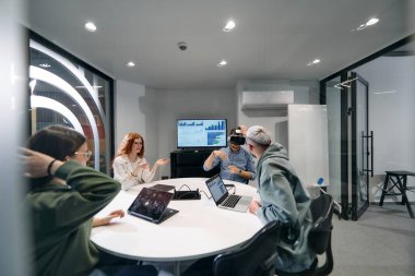 Çeşitli iş adamları, sanal gözlük takan, gelecekteki çalışma alanlarında yenilik ve yaratıcılık sergileyen yeni bir sanal gerçeklik teknolojisini dener ve denerler..