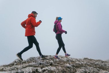 Dağ yolunda koşan bir çiftin izini sürüyorum. Bir çift sabahın erken saatlerinde kros koşusu yapıyor..